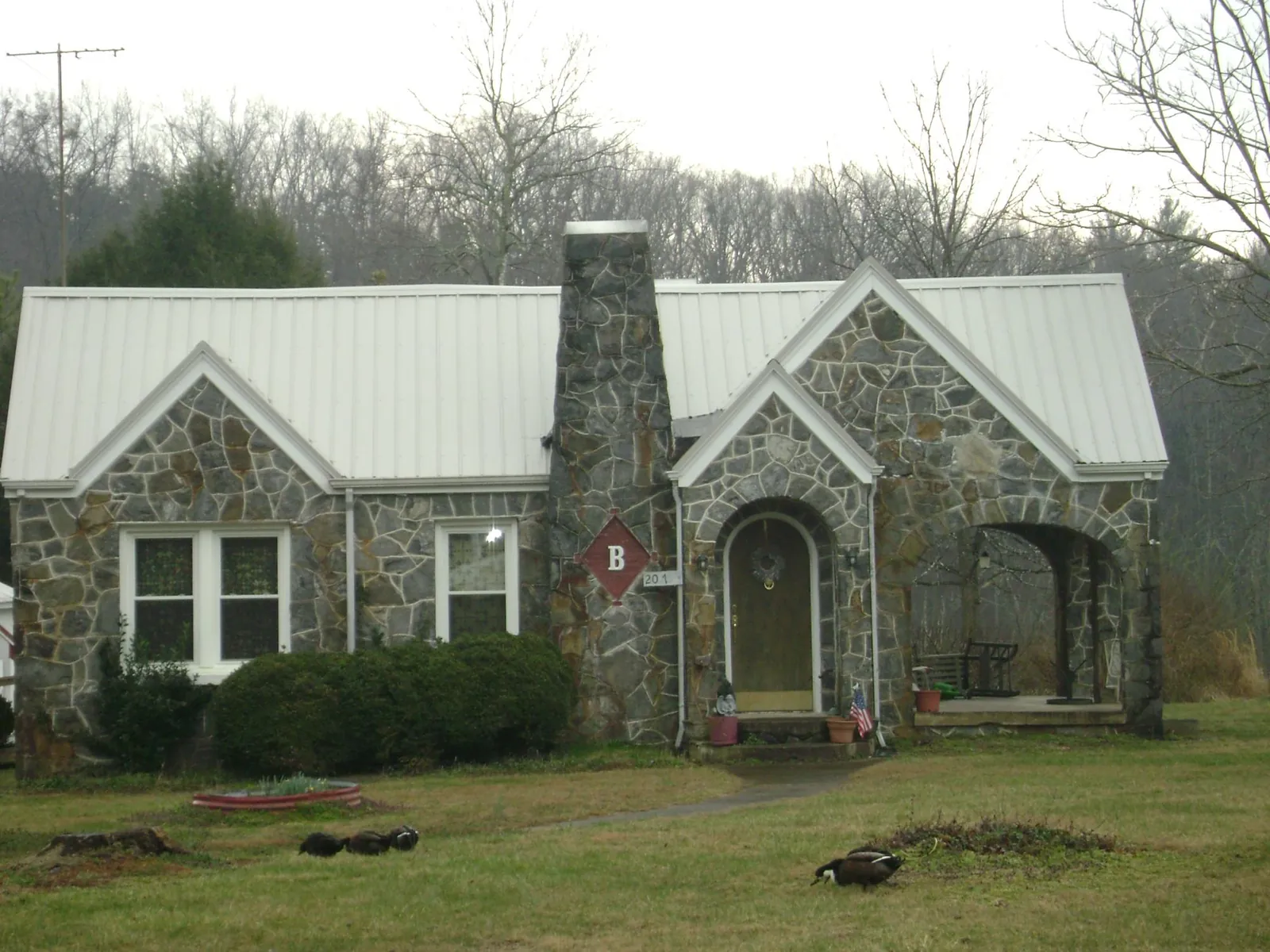 White metal roof on a stone cottage with steep gables in Reno