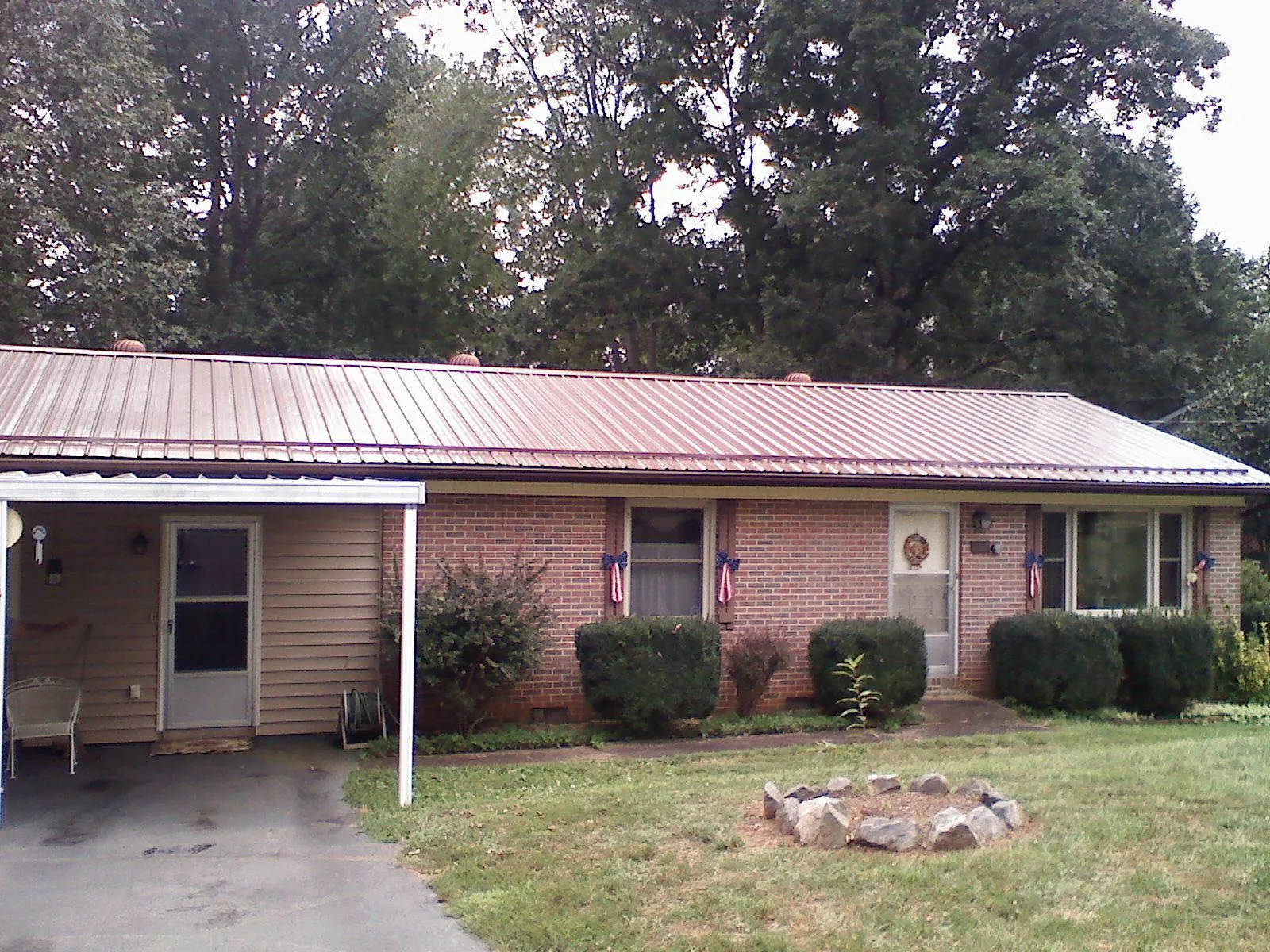 Bronze metal roof and carport on a brick ranch home — Roof Repair work by our crew in Reno